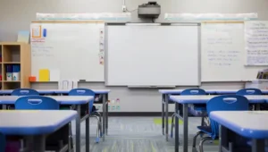 Empty classroom with desks and whiteboard, representing school safety concerns and parenting anxiety in uncertain times