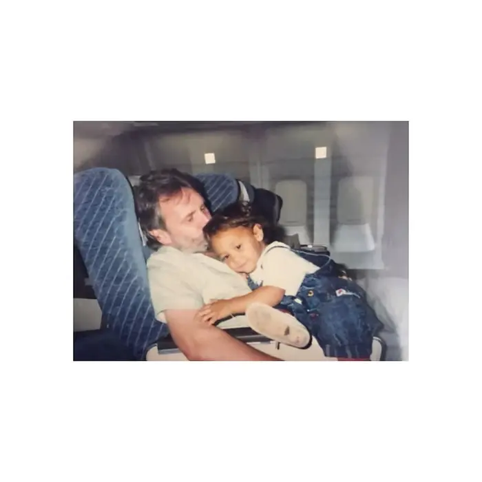 Photo of a father holding his child on a plane, representing memory, attachment, and the emotional complexity of grief and parent-child relationships