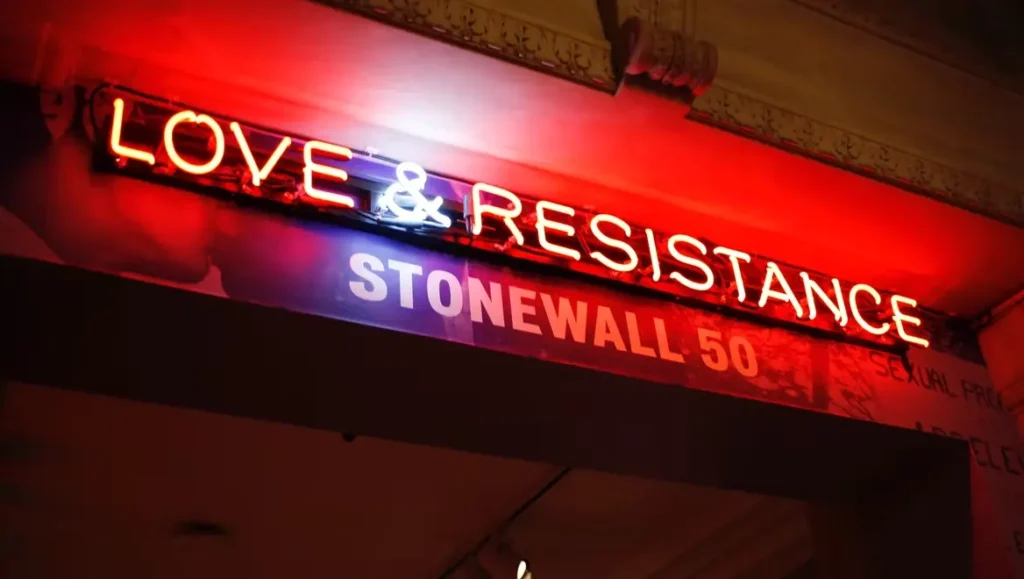 love-resistance-neon-sign-lgbtq-community-healing Neon sign reading love and resistance, representing LGBTQ+ resilience, community strength, and healing through collective joy